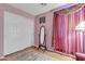 Pink bedroom featuring wood floors, ample closet space, and soft natural light from the window at 2859 E Cathy Dr, Gilbert, AZ 85296