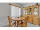 Cozy dining area features a round wood table with seating for four and a charming china cabinet at 2859 E Cathy Dr, Gilbert, AZ 85296