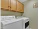 Spacious laundry room with overhead cabinets, featuring a large washing machine and dryer set at 2859 E Cathy Dr, Gilbert, AZ 85296