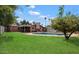 Lush backyard with a pool, well-manicured lawn, and shade tree for outdoor relaxation at 2942 E Mulberry Dr, Phoenix, AZ 85016