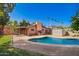 Backyard showcasing a lovely pool, brick patio, grassy area, and mature trees at 2942 E Mulberry Dr, Phoenix, AZ 85016