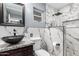 Modern bathroom featuring marble backsplash, a unique black sink, and rainfall showerhead at 2942 E Mulberry Dr, Phoenix, AZ 85016