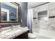 Bathroom featuring granite countertops, updated tile work, and shower-tub combo at 2942 E Mulberry Dr, Phoenix, AZ 85016