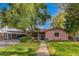Charming home featuring a lush green lawn, mature trees, and a covered carport, offering both beauty and practicality at 2942 E Mulberry Dr, Phoenix, AZ 85016