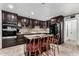 Modern kitchen featuring dark cabinets, a granite island with bar seating, and stainless steel appliances at 2942 E Mulberry Dr, Phoenix, AZ 85016