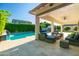 Covered patio looks out onto the pool, lawn, and greenery in the backyard at 2973 E Austin Dr, Gilbert, AZ 85296