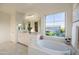Well-lit bathroom featuring a soaking tub, large window, and double sink vanity at 2973 E Austin Dr, Gilbert, AZ 85296