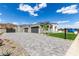 A patterned stone driveway leading to a luxurious single-story home with a three-car garage at 3046 W Redwood Ln, Phoenix, AZ 85045