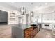 Spacious kitchen island boasts wooden cabinets, granite countertops, stainless steel appliances, and modern light fixtures at 3046 W Redwood Ln, Phoenix, AZ 85045