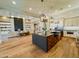 Open-concept kitchen with stainless steel appliances, dark island, and wood floors at 3046 W Redwood Ln, Phoenix, AZ 85045