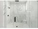 Modern shower boasts marble-patterned walls, clear glass, black fixtures, and white mosaic tile flooring at 3046 W Redwood Ln, Phoenix, AZ 85045