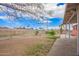 A view of the spacious dirt back yard including the chain link fence and some trees at 3149 N 40Th Ln, Phoenix, AZ 85019