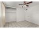 The bright bedroom has tile floors, a ceiling fan, a closet and a white door at 3149 N 40Th Ln, Phoenix, AZ 85019
