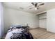 Relaxing bedroom with an open closet, neutral tones, tiled floors, and a ceiling fan for a minimalist, peaceful retreat at 3149 N 40Th Ln, Phoenix, AZ 85019