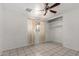 This bedroom features tile floors, a ceiling fan, window with curtains, and a closet at 3149 N 40Th Ln, Phoenix, AZ 85019