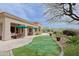 Beautiful backyard boasts a putting green, covered patio, and lush landscaping, perfect for outdoor living at 33242 N 68Th Pl, Scottsdale, AZ 85266