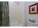 Clean bathroom showcasing a tiled shower/tub and a neutral shower curtain for an elegant and simple design at 33242 N 68Th Pl, Scottsdale, AZ 85266