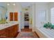 Bathroom featuring dual vanities, walk-in closet access, and soaking tub at 33242 N 68Th Pl, Scottsdale, AZ 85266