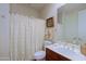 Neat bathroom with a single vanity, framed mirror, and a shower-tub combination with a curtain at 33242 N 68Th Pl, Scottsdale, AZ 85266
