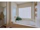 Bright bathtub with decorative glass block window and surrounding tile at 33242 N 68Th Pl, Scottsdale, AZ 85266