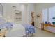 Cozy bedroom with plush bedding, complemented by plantation shutters and tasteful decor and an attached bathroom at 33242 N 68Th Pl, Scottsdale, AZ 85266