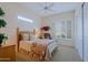 Sunlit bedroom with comfortable bed and window with plantation shutters offers a warm, inviting retreat at 33242 N 68Th Pl, Scottsdale, AZ 85266
