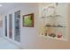 Bright hallway showcasing unique decorative niche with glass shelving for artful display alongside framed artwork at 33242 N 68Th Pl, Scottsdale, AZ 85266