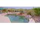 Luxurious pool and spa area with natural rock details, complemented by vibrant desert plants and lush landscaping at 33242 N 68Th Pl, Scottsdale, AZ 85266