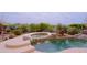 Beautiful pool and spa area with rock accents, surrounded by lush desert landscaping for a private oasis at 33242 N 68Th Pl, Scottsdale, AZ 85266