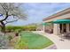 Charming backyard with a putting green, outdoor kitchen, and comfortable seating, perfect for relaxing and entertaining at 33242 N 68Th Pl, Scottsdale, AZ 85266