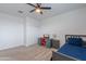 This bedroom is well-lit and includes a bed, desk, ceiling fan, and a closet with sliding doors at 37185 N Falabella Dr, San Tan Valley, AZ 85140