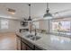 Spacious kitchen island with seating, open to the living and dining areas, with modern lighting fixtures at 37185 N Falabella Dr, San Tan Valley, AZ 85140