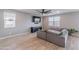 Spacious living room with wood flooring, ceiling fan, mounted TV, and comfortable sectional sofa at 37185 N Falabella Dr, San Tan Valley, AZ 85140