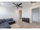 Bright living room with a blue sectional sofa, neutral carpet, ceiling fan, and built in storage at 37185 N Falabella Dr, San Tan Valley, AZ 85140
