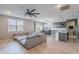Open-concept living space with ceiling fan, kitchen with island, dining area, and comfortable sectional sofa at 37185 N Falabella Dr, San Tan Valley, AZ 85140