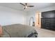 Cozy bedroom featuring a gray upholstered bed, a dresser, a mirror, and a modern ceiling fan at 37185 N Falabella Dr, San Tan Valley, AZ 85140