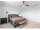 Cozy bedroom featuring a gray upholstered bed, stylish bedside tables, a leather bench, and modern fan at 37185 N Falabella Dr, San Tan Valley, AZ 85140