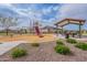 Community playground with a slide, climbing structure, and picnic area for Gathering fun at 37185 N Falabella Dr, San Tan Valley, AZ 85140