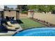 Expansive backyard features artificial turf, a pool, a patio, and lounge chairs at 4038 W Windrose Dr, Phoenix, AZ 85029