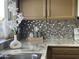 Modern kitchen showcasing granite countertops, tile backsplash, and bright natural light at 4038 W Windrose Dr, Phoenix, AZ 85029