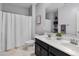 Bright bathroom featuring a dual vanity, framed mirror, walk-in shower, and neutral-toned walls at 4087 W Coneflower Ln, San Tan Valley, AZ 85144