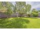 Large backyard featuring lush green grass, mature trees, and a well-maintained landscape at 4215 S Marisol Ln, Gilbert, AZ 85297