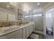 A bright bathroom with dual sinks, mosaic backsplash, and a frameless glass shower at 4215 S Marisol Ln, Gilbert, AZ 85297