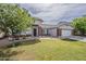 Well-maintained home featuring brick details, lush lawn, and a two-car garage under a blue sky at 4215 S Marisol Ln, Gilbert, AZ 85297