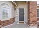 Charming home entrance with a gray front door, sidelight window, and brick details at 4215 S Marisol Ln, Gilbert, AZ 85297