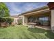 Beautiful backyard featuring a covered patio, fire pit, and lush green artificial grass at 4497 E Ficus Way, Gilbert, AZ 85298