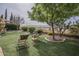 Lush backyard featuring mature trees, desert landscaping, and outdoor seating at 4497 E Ficus Way, Gilbert, AZ 85298