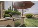 Backyard with a built-in barbeque grill, countertop space, and an umbrella for a pleasant outdoor dining experience at 4497 E Ficus Way, Gilbert, AZ 85298
