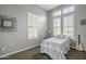 Bright bedroom featuring three large windows with plantation shutters, a ceiling fan, and neutral decor at 4497 E Ficus Way, Gilbert, AZ 85298