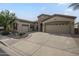 Inviting single-story home featuring a low-maintenance yard and a spacious driveway leading to a three-car garage at 4497 E Ficus Way, Gilbert, AZ 85298